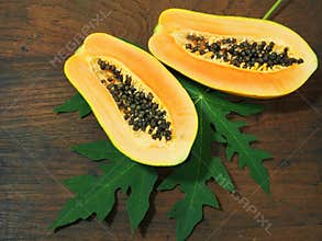 Papaya with green leaf on wooden background