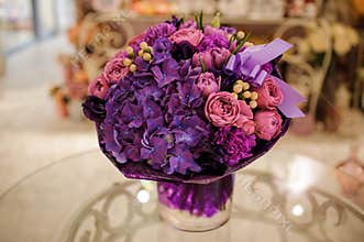 Purple flower bouquet composition on table