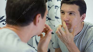 Man with Problem Skin in front of the mirror