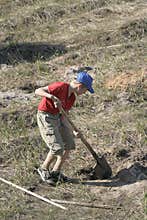 Boy digging in field