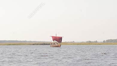 Vikings are floating on the river on the Drakkar