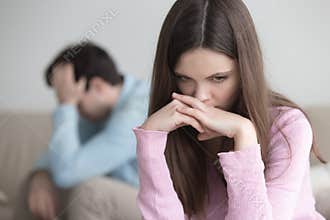 Upset young couple after arguing, sad thoughtful woman looking w
