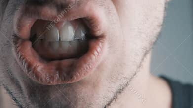 Close-up of angry man screaming against white background.