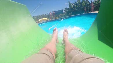 Handsome young man sliding down water slide