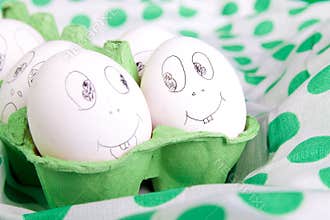Easter eggs with funny faces in the green