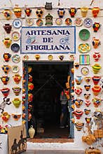 Crowded colorful pottery displayed on shop entrance at Frigiliana, Spain