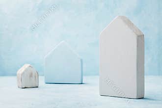 Model of a wooden house on blue background. Construction real estate, insure home, building, mortgage and architectural concept.