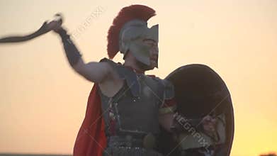 The tired gladiator attacks the other and he dodges and strikes back, slow motion