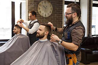 Barber make haircut with scissors to client at barbershop