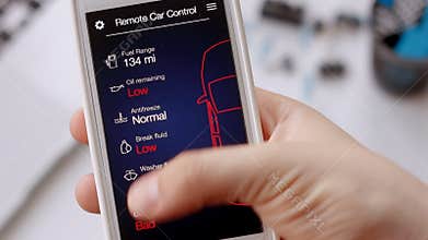 Man checks car information on his mobile device. Bad condition, car need repair. Car remote control using smartphone