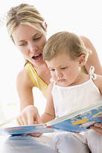 Mother and baby reading book indoors