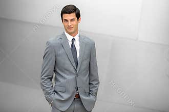 Grinning businessman in a trendy suit young and positive expression at the office modern corporate leader