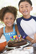 Two children in kitchen with birthday cake