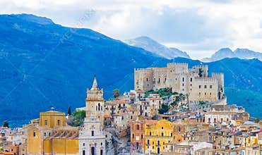 Caccamo town on the hill with mountains background on cloudy day in Sicily.