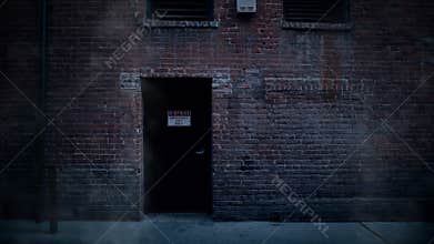 Back door entrance to old brick building in alley with steam rising.