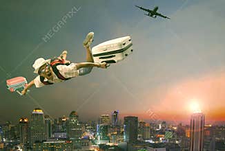 Younger man flying mid air with belonging luggage and passenger