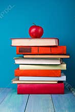 Stack of colorful books, grungy blue background, free copy space