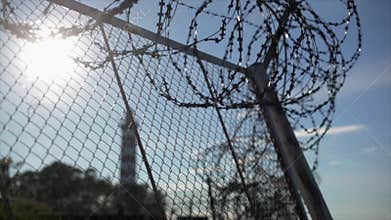 Barbed wire fence under sun focus in out. Summer. Jail. Lighthouse background