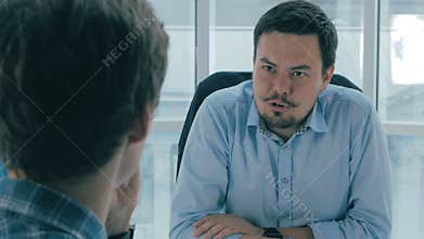 Job interview. Manager, boss in office talking with an applicant. Over the shoulder view.