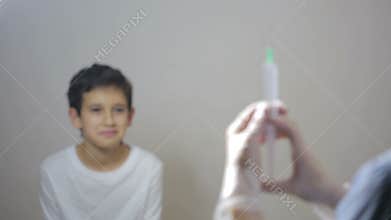 Cute little boy afraid of injection. nurse prepares a syringe