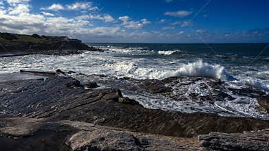 Winter storm waves breaking over roack sea spray