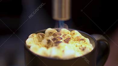 Blow torch is burning fire on seasonal holiday marshmallow cocktail