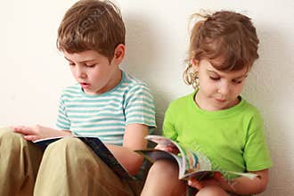 Brother and sister sitting and read books