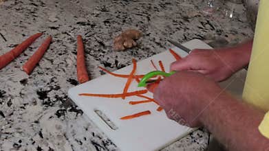 Man peeling organic carrots onto a white plastic cutting board