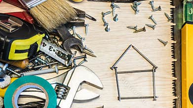 House design, house planning, house made of nails on the background of tools