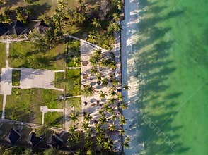 Aerial shot of a luxury hotel on a Beach first line with Palm Trees Drops their Shades on a High Tide Water of Indian