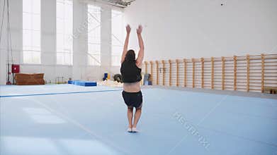A male athlete is making four back flips, steadicam, front view, slow motion.