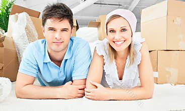 Smiling couple on the floor after unpacking boxes