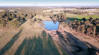 Long Shadows and gum trees by a dam in the bush, Australia