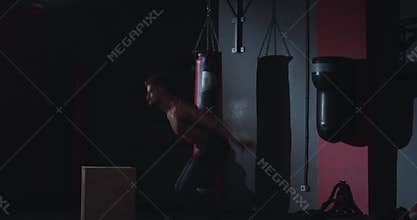 In a cross fitness class strong athletic guy doing the box jumping exercises on the wooden crates , have a intense