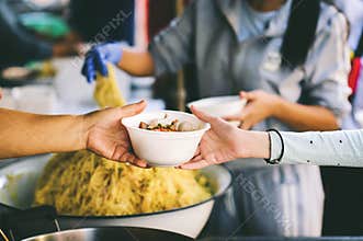 The poor reach out to receive donated food: Homeless people receive free charity food