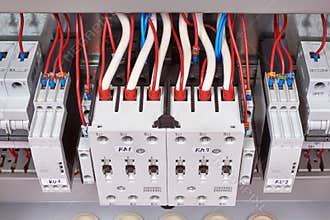 Electrical cables and wires are connected from the top to the contactors or starters and relays of control of phases
