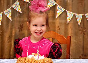 Little happy girl celebrating her birthday at the festive dinner