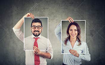 Happy man and woman holding self portraits