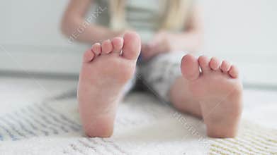 A close-up of the child`s feet playing the designer of the house on the floor