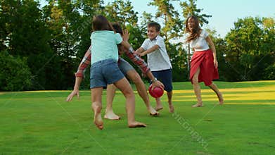 Man holding ball in hands outdoors. Mother with children trying to catch ball