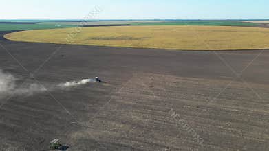 Agricultural tractor performing fall tillage in stubble field