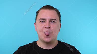 Caucasian man sticks out his tongue cut out on a blue background