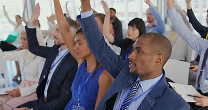 Audience at a seminar raising hands to ask questions