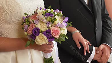 Bride and groom arm in arm, close up on hands