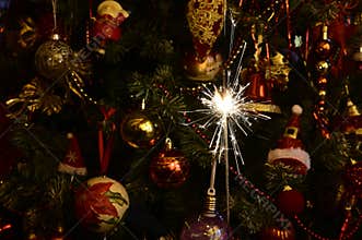 Small fireworks in front of christmas tree on New Year`s Eve