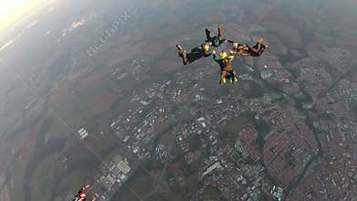 Skydivers make a formation skydive at the sunset