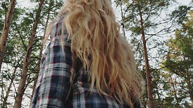 Low angle view of girl looking up at sky in forest