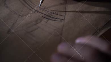 Man draws the design of future wood furniture in a luxurious style which will be created from Ecological Materials in