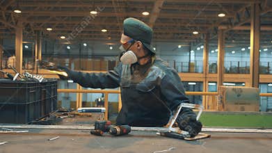 Man destroys a device while working in a recycling facility.