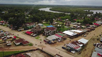 Aerial Third World Country Street with River and Lush Jungle in Background